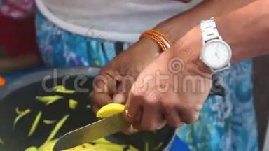 在斯里兰卡Kandy，一个卖<strong>芒果</strong>的小贩用刀切<strong>芒果</strong>